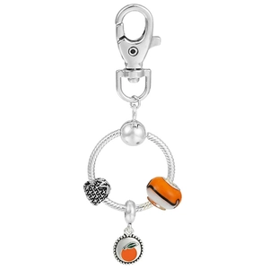 Detail of fruit pendant keychain with orange charm and green leaves on silver snake chain