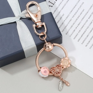 Rose gold DIY keychain with pink cat paw and dreamcatcher heart charms on a round loop