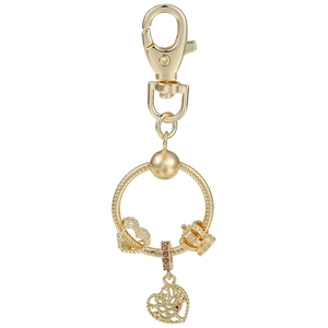Détails de pendentifs arbre de vie dorés et breloques couronne sur un porte-clés doré