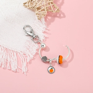 DIY beaded fruit keychain with silver hardware and a bright orange slice charm pendant
