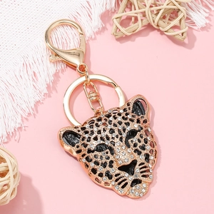 Portachiavi testa di leopardo scintillante con placcatura in oro e strass su sfondo decorato