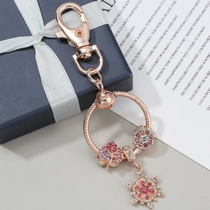 Rose gold keychain with crystal maple leaf and snowflake charms in a gift setting