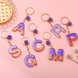 Purple and gold foil gradient resin letter keychain with star sequins and pompom charm