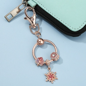 Rose gold keychain featuring sparkling maple leaf, snowflake, and pavé bead charms
