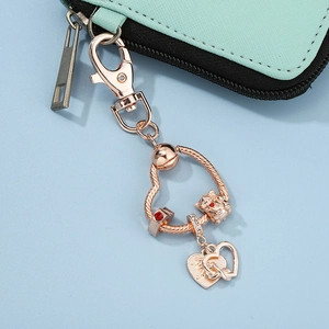 Rose gold heart keychain featuring bear pendant and red crystal charm on snake chain ring