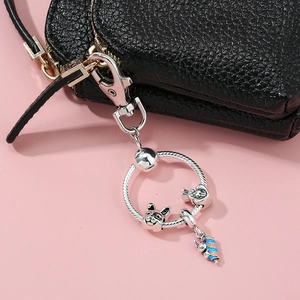 Silberner Hasen-Schlüsselanhänger mit Karotten-Charm an einer schwarzen Tasche
