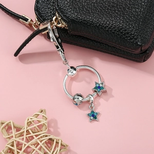 Funkelnder Kristallstern Schlüsselanhänger in Silber auf einer schwarzen Ledertasche