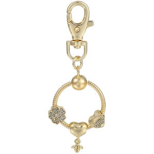 Detail of a golden bee charm and rhinestone flower pendant on a keychain ring