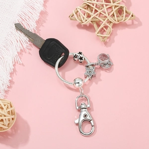 Porte-clés étoile argenté avec strass et fermoir homard sur fond rose pastel