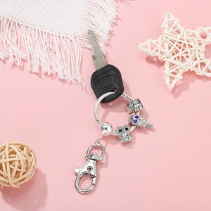 Silver owl beaded DIY keychain with round ring and lobster clasp on pink background