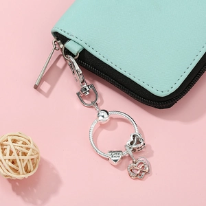 Silver and rose gold infinity heart keychain with Amour engraving on blue purse