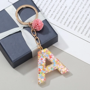 Porte-clés lettre A en résine avec paillettes colorées et un pendentif pompon rose doux