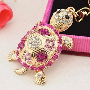 Golden tortoise keychain with pink rhinestones shown from a 45-degree angle