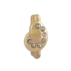 Boucle d'oreille huggie dorée avec pierres de zircone sur un fond blanc neutre