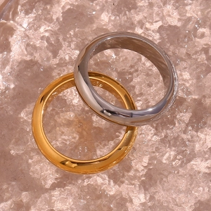 Detailed view of thick 18K gold and silver dome rings on premium textured background