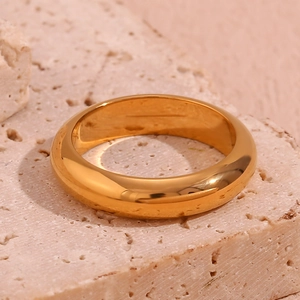 Macro detail of minimalist 18K gold plated stainless steel ring on natural stone