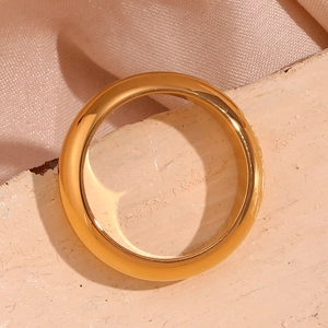 Macro shot of 18K gold plated thick dome ring on warm textured aesthetic background