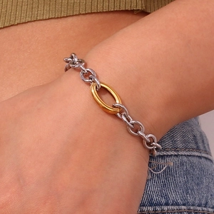 Detail of a two-tone chain bracelet featuring mixed silver and gold links on a wrist