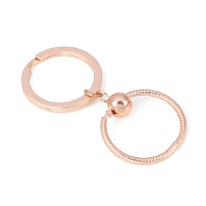 Rose gold O-shaped pendant keychain with snake bone texture on a minimalist background