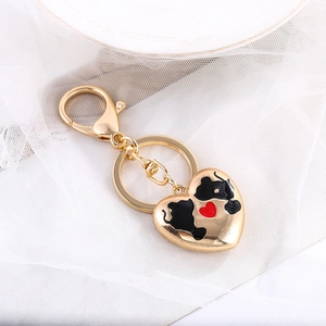 Détail d'un porte-clés en métal doré en forme de cœur avec accents en émail rouge