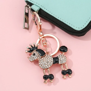 Détail d'un porte-clés caniche or rose serti de strass blancs et d'émail noir brillant
