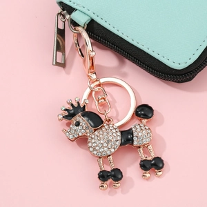 Porte-clés caniche étincelant avec cristaux et couronne noire sur fond rose doux