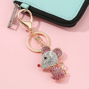 Gros plan d'un porte-clés souris doré orné de strass roses et blancs sur du cuir