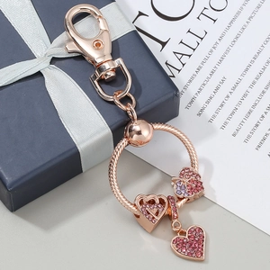 Portachiavi cuore oro rosa con cristalli rosa e viola su sfondo scatola regalo