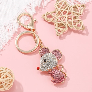 Porte-clés souris dorée avec strass roses, fermoir mousqueton et anneau sur fond rose