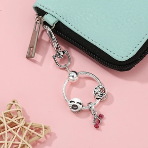 DIY silver charm keychain with smile, lip and heart pendants on blue leather bag