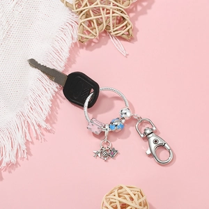Silver airplane and camera charm keychain with pink enamel and globe pendants
