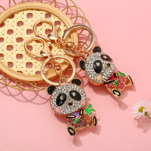 Panda Schlüsselanhänger mit Goldbeschichtung und bunten Straßsteinen auf rosa Hintergrund