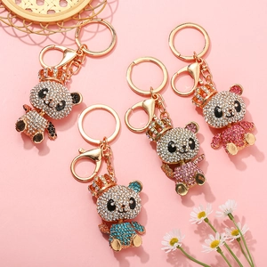 Détail de porte-clés panda en cristal avec couronnes en noir, bleu, rose et violet