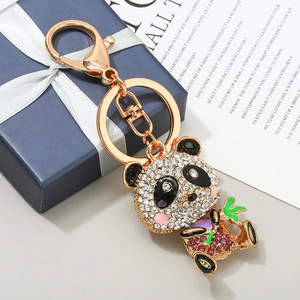 Funkelnder Panda-Schlüsselanhänger mit Goldplattierung und Strass neben Geschenkbox