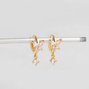 Détail de créoles papillon en or 18 carats avec des pierres en zircone marquise
