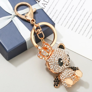 Porte-clés panda doré avec couronne de cristaux et strass sur une boîte cadeau