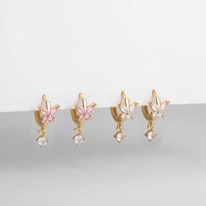 Détails macro de boucles d'oreilles créoles papillon en or 18 carats avec zircons roses