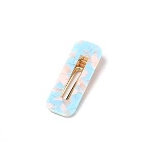 Detail of rectangular acrylic hair clip featuring blue and pink marble texture with gold clip