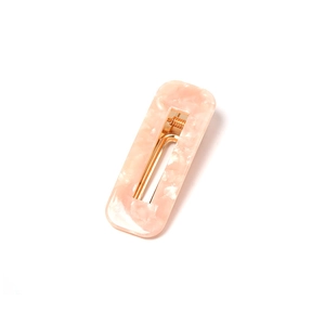 Detail of pink marble acetate hair clip with polished gold metal fastener