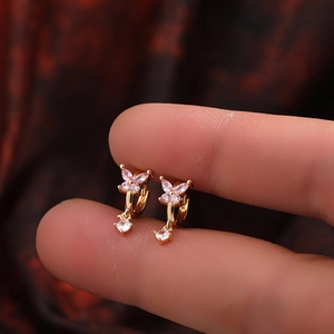 Détail de boucles d'oreilles papillon en or 18 carats avec pierres en zircon rose