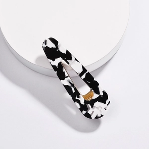 Detailed macro view of large teardrop hair clip with black and white marble acetate finish