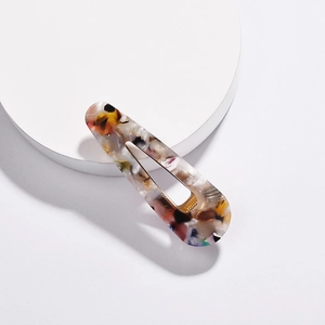 Detail of teardrop acetate hair clip featuring colorful marbled textures and metal teeth
