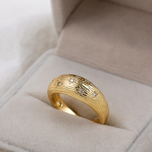 Gedetailleerde macro van retro 18K gouden ring met getextureerd metaal en zirkonia sterren