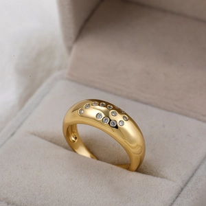 Gedetailleerde opname van een 18K gouden dome ring met glanzende zirkonia sterpatronen