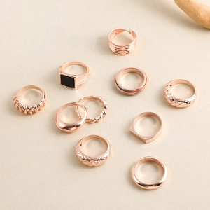 Flachbild von 10-teiligem roségoldenem Ringset mit geometrischen Mustern und schwarzen Steinen