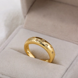Detail van 18K gouden ring met geborstelde textuur en stervormige zirkoon inlays