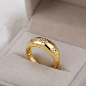 Detailopname van 18K gouden ring met sterpatroon en zirkonia stenen in een doosje