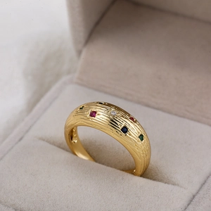 Macro-opname van 18K gouden ring met gekleurde zirconen in beige fluwelen doosje