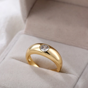 Macro-opname van 18K vergulde ring met ronde zirkoon in een grijze fluwelen sieradendoos