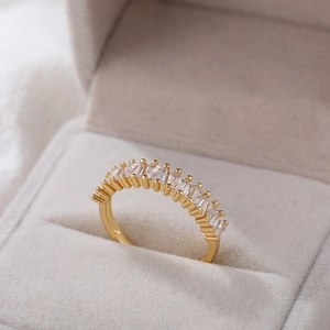 Detailopname van 18K gouden ring met baguette-zirkonia in een beige juwelendoosje
